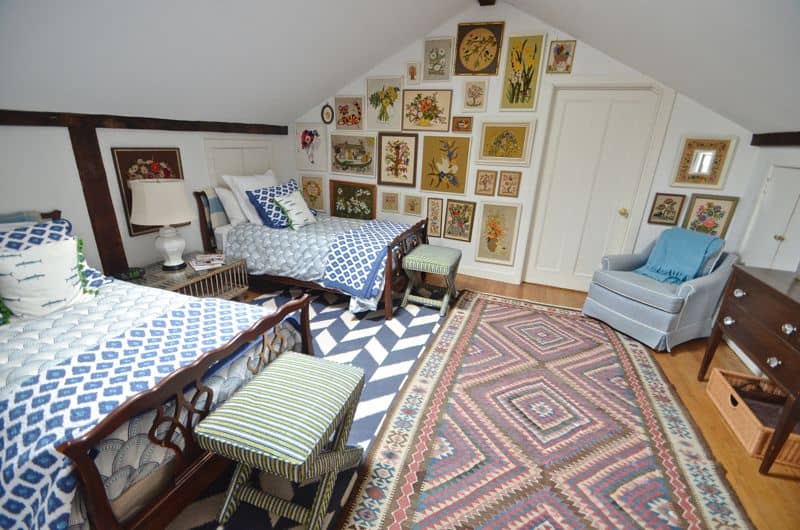 Guest bedroom with mixed patterns and textures. Gallery wall of embroidered art.